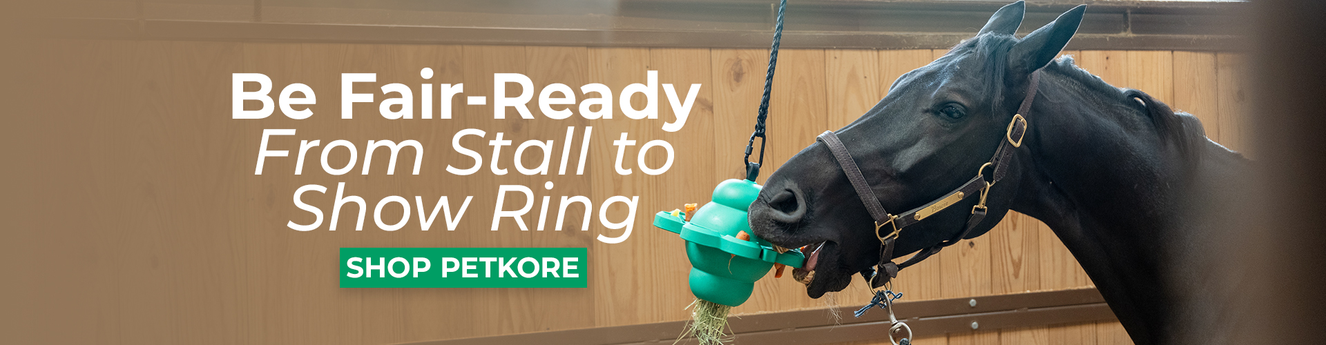 Promotional banner showing a black horse in a wooden stall interacting with a green hanging feeder. Overlay text reads “Be Fair-Ready From Stall to Show Ring” with a green button labeled “Shop PetKore.”