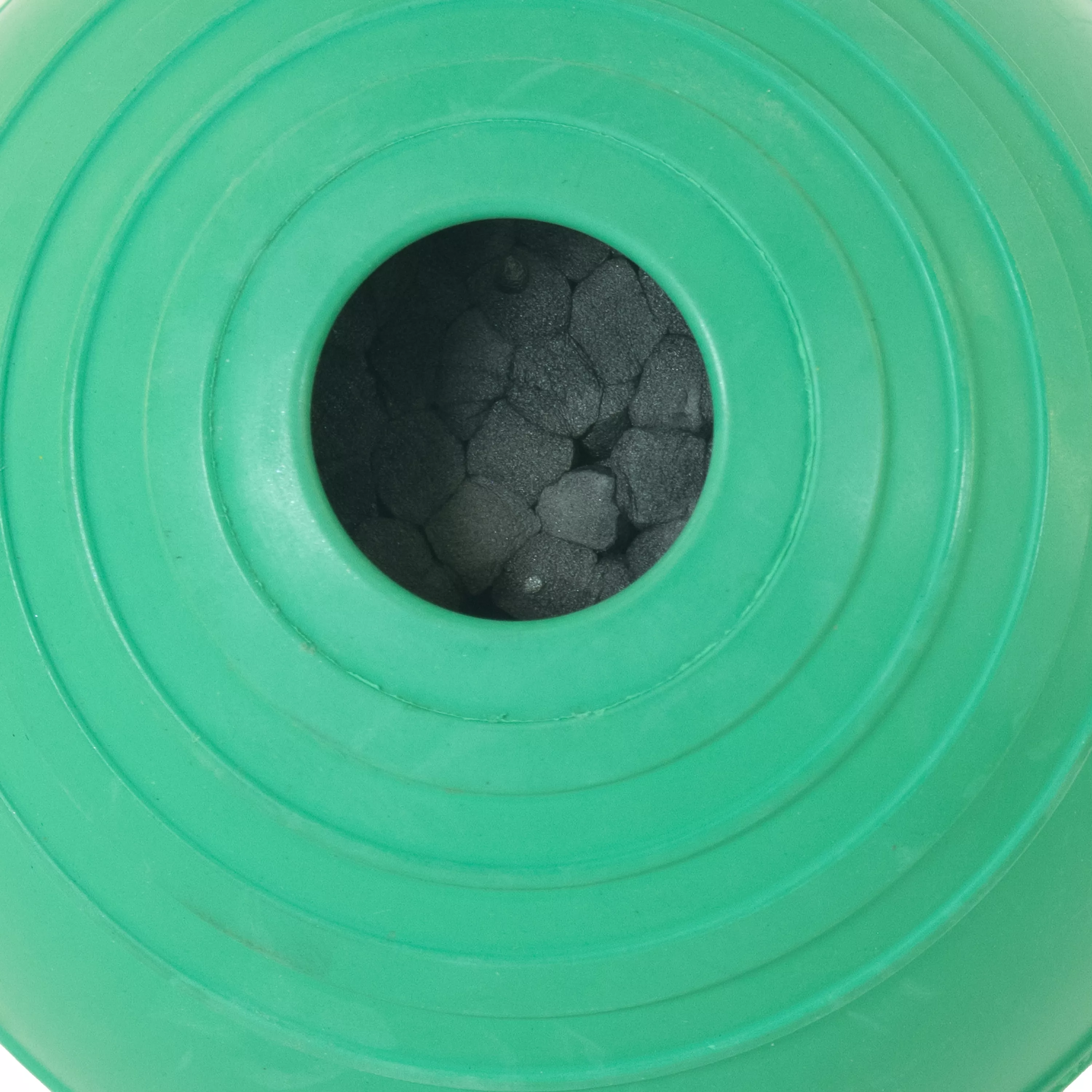 Closeup of green rubber ball toy with dark foam inside.