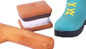 A set of latex dog toys shaped like a stick, s'more, and green boot.