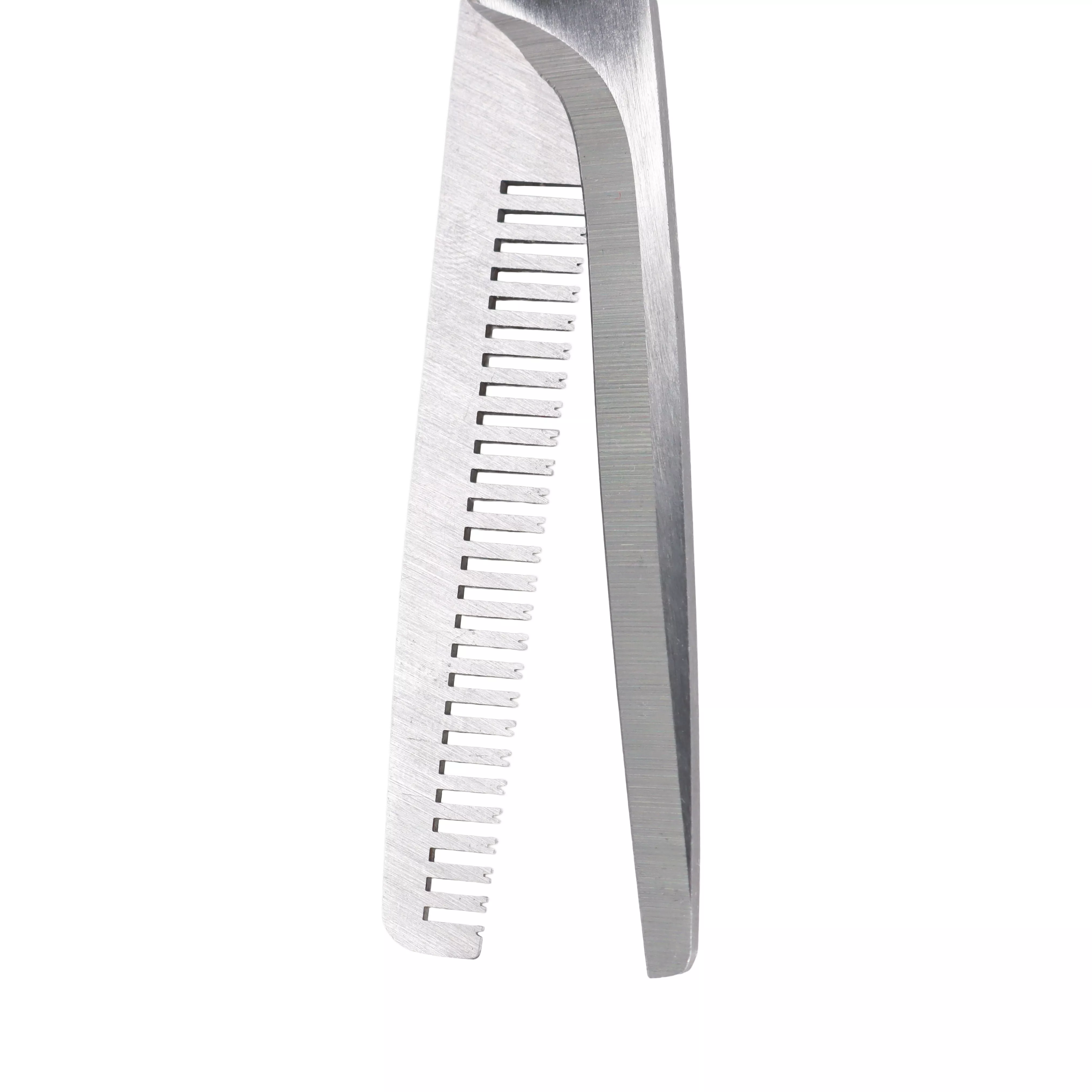 A close‑up view of the thinning shears’ toothed blade is shown against a white background. The silver‑tone metal blade has a row of evenly spaced rectangular teeth, and the second smooth blade is partially visible behind it.