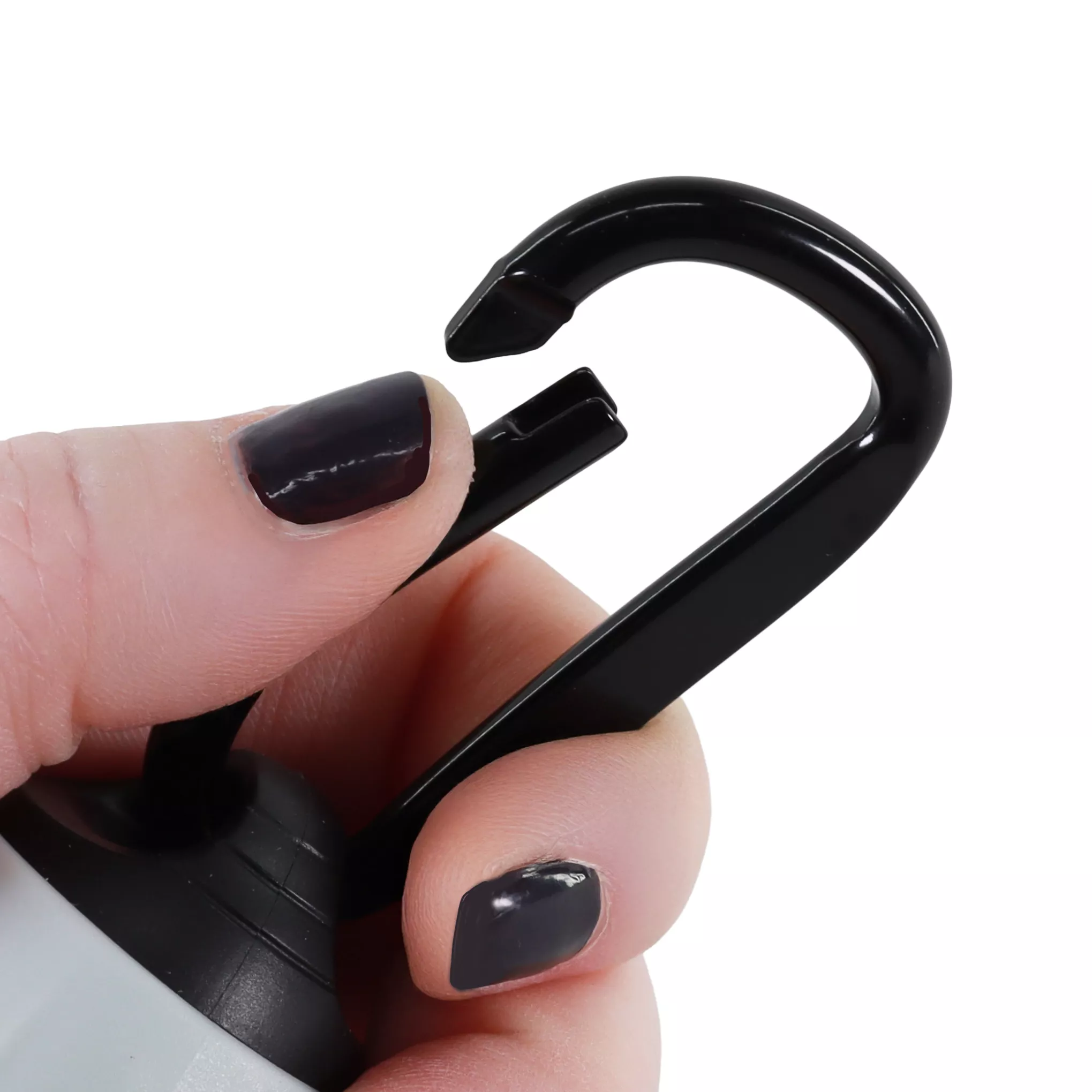 A person is pinching a black carabiner clip into an open position.