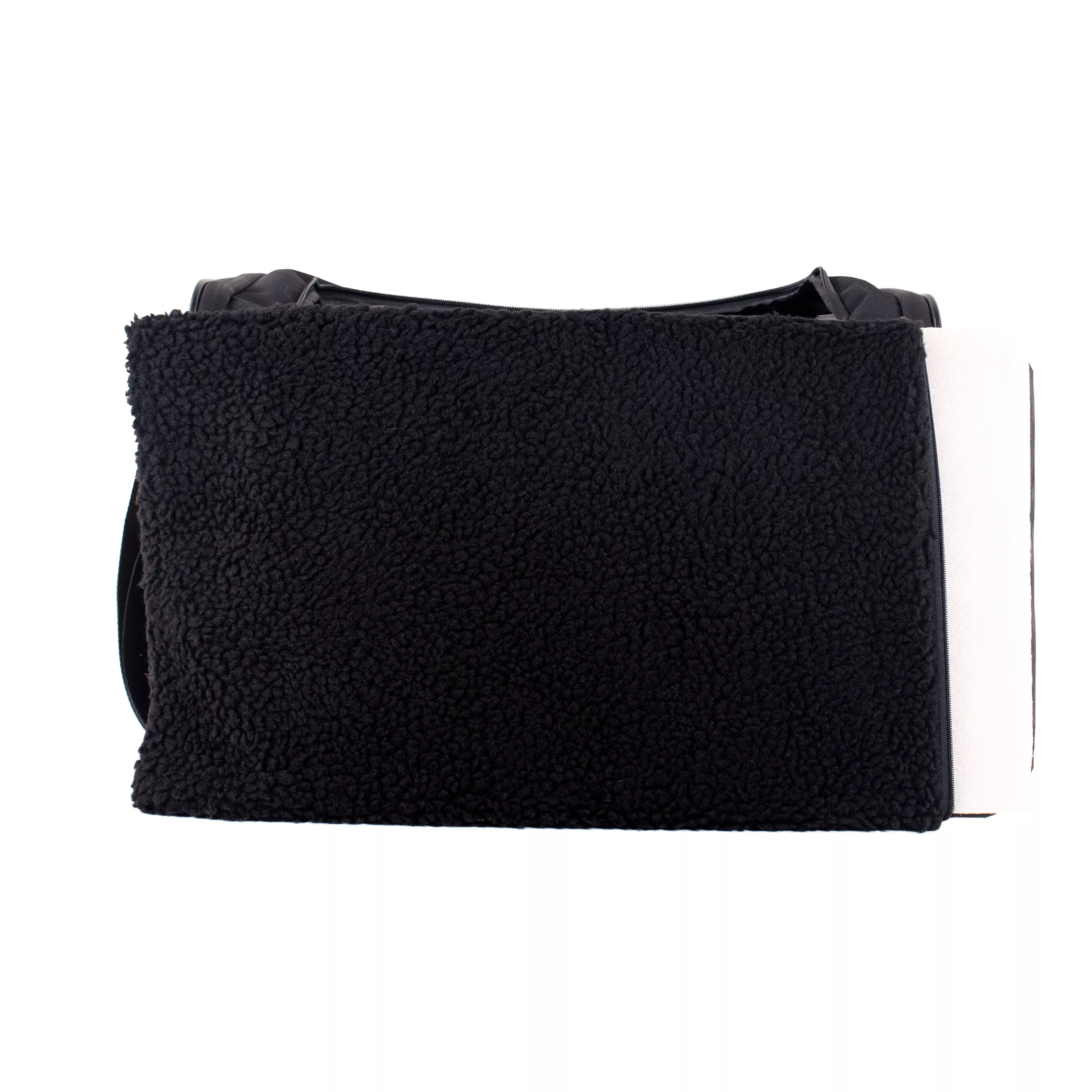 Side view of the tote carrier with the removable fleece pad pulled out and resting beside the opening.