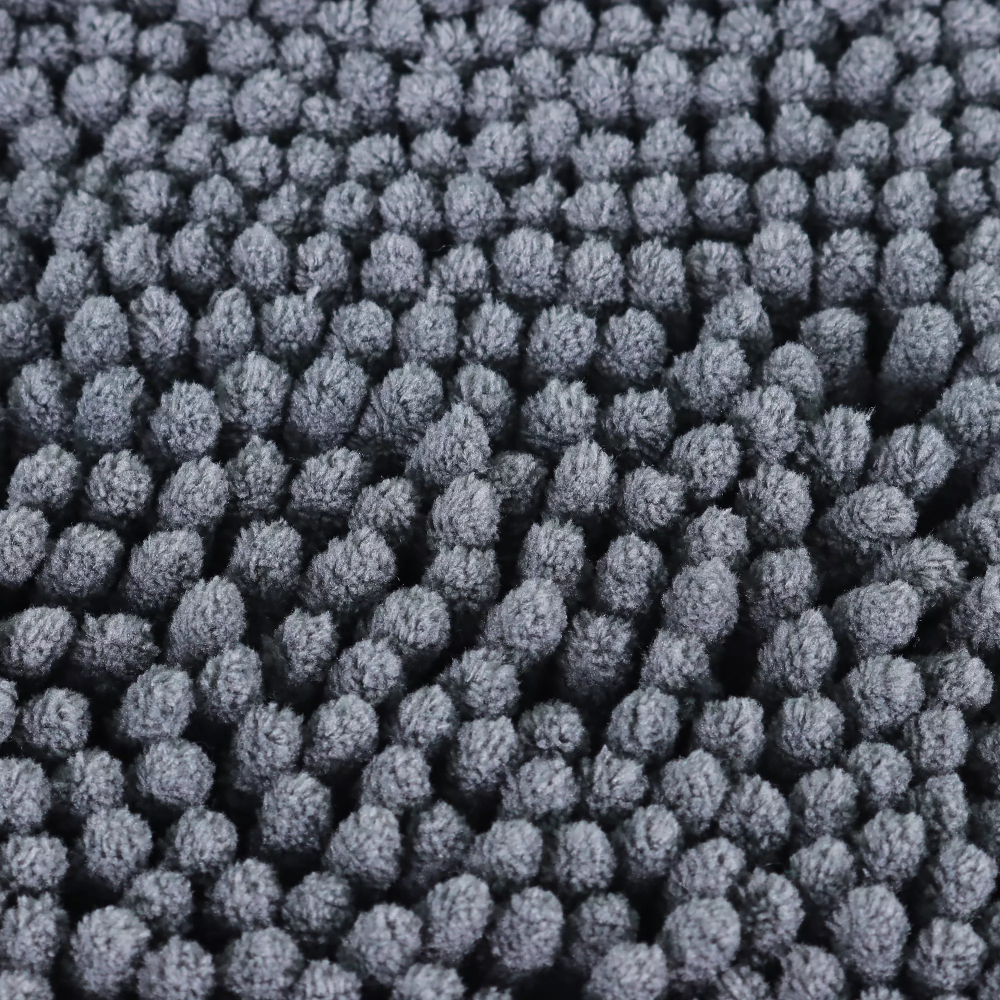 A close‑up view of the shammy towel’s microfiber chenille surface shows densely packed gray, finger‑shaped strands forming a soft, absorbent texture. The strands vary slightly in size and cluster closely together, creating a uniform appearance across the towel.