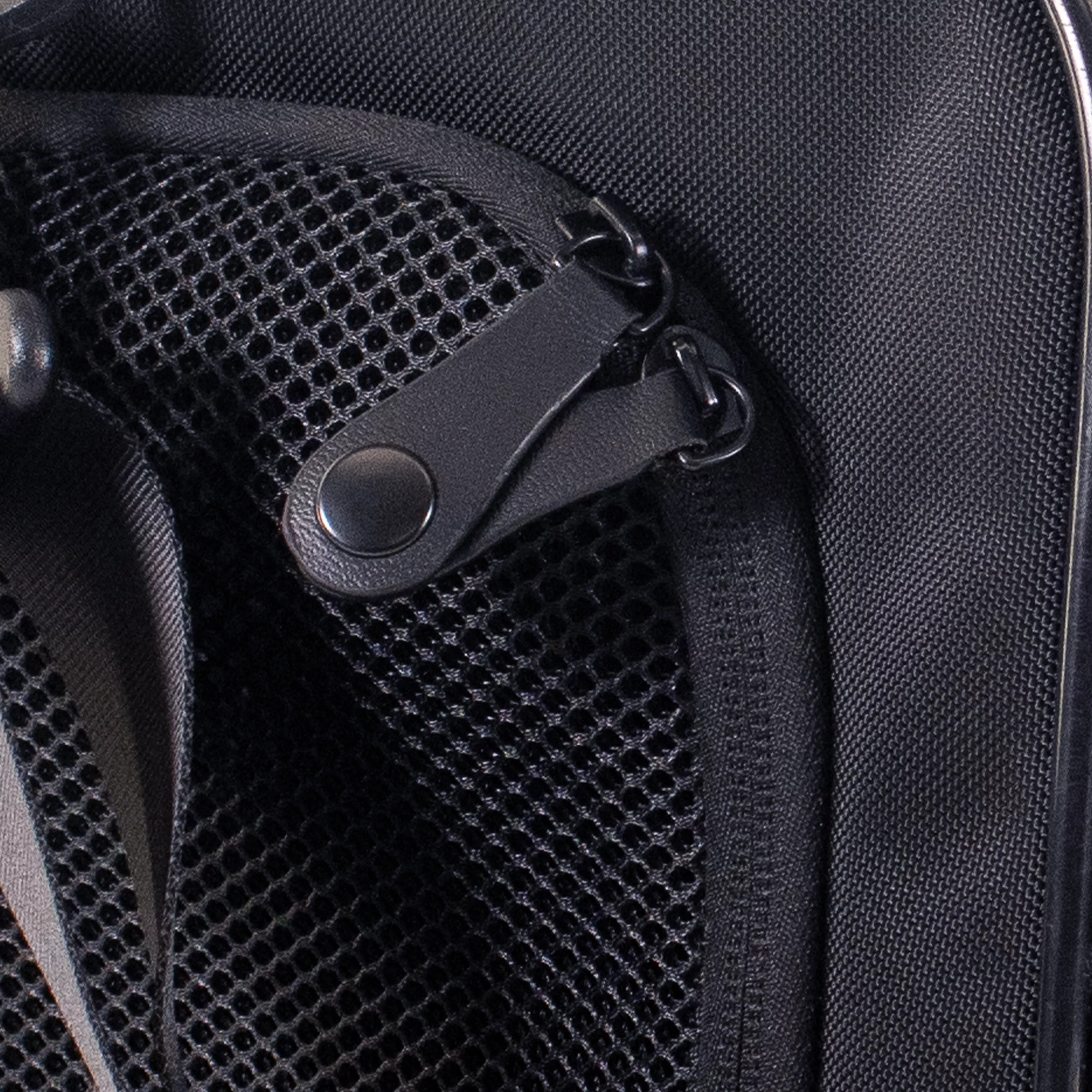 Close‑up of the tote carrier’s zipper pull and mesh ventilation panel, showing the stitching, hardware, and fabric texture.