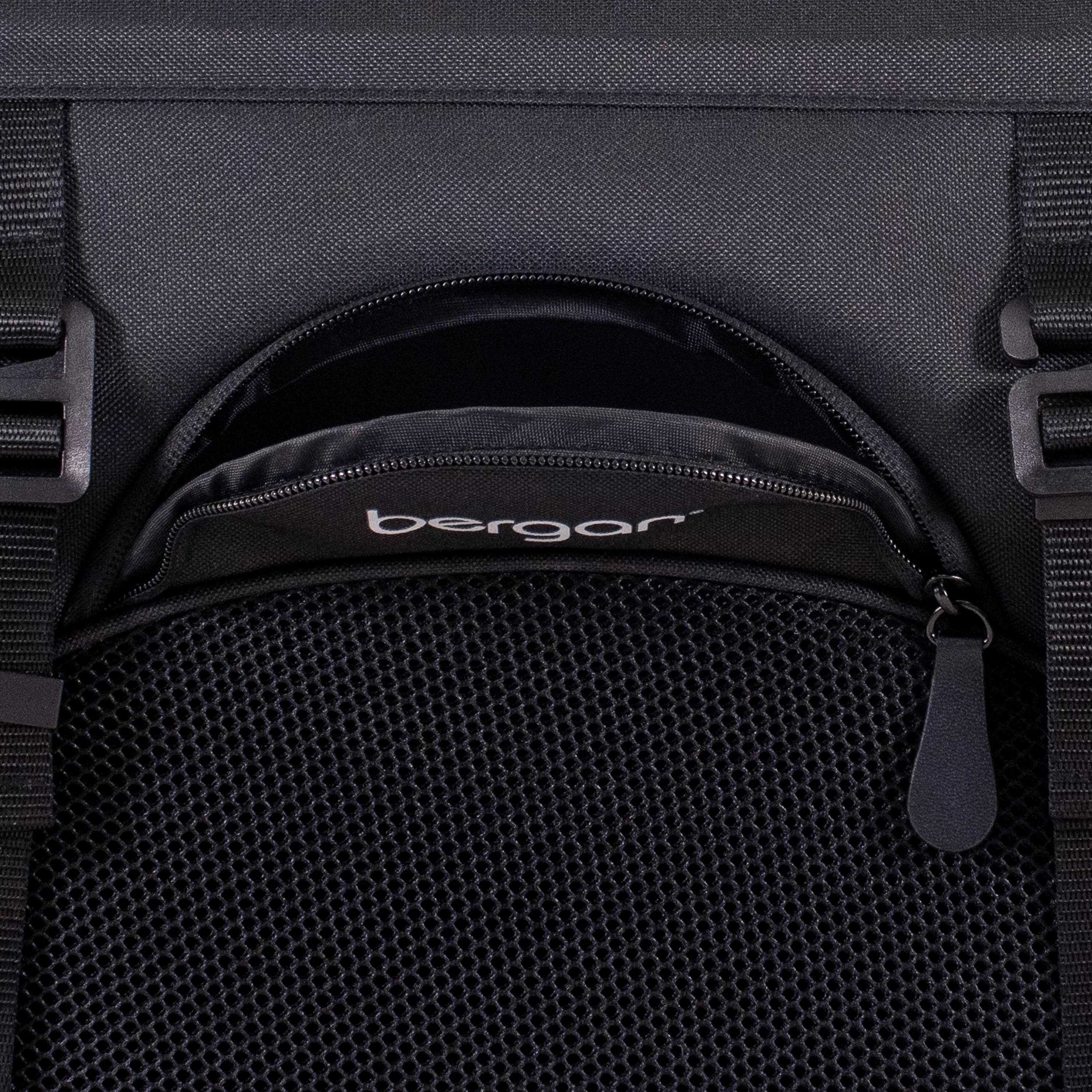 Close-up of the PetConnect pocket on the front of the pet carrier, showing the partially opened curved zipper pocket with mesh fabric below and adjustable straps on each side.