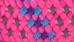 A swatch presenting a repeating geometric weave of diamond shapes in bright pink, soft teal, lavender, and deep magenta. The overlapping braided pattern creates a three‑dimensional visual texture, with each color forming a distinct section of the interlocked design.