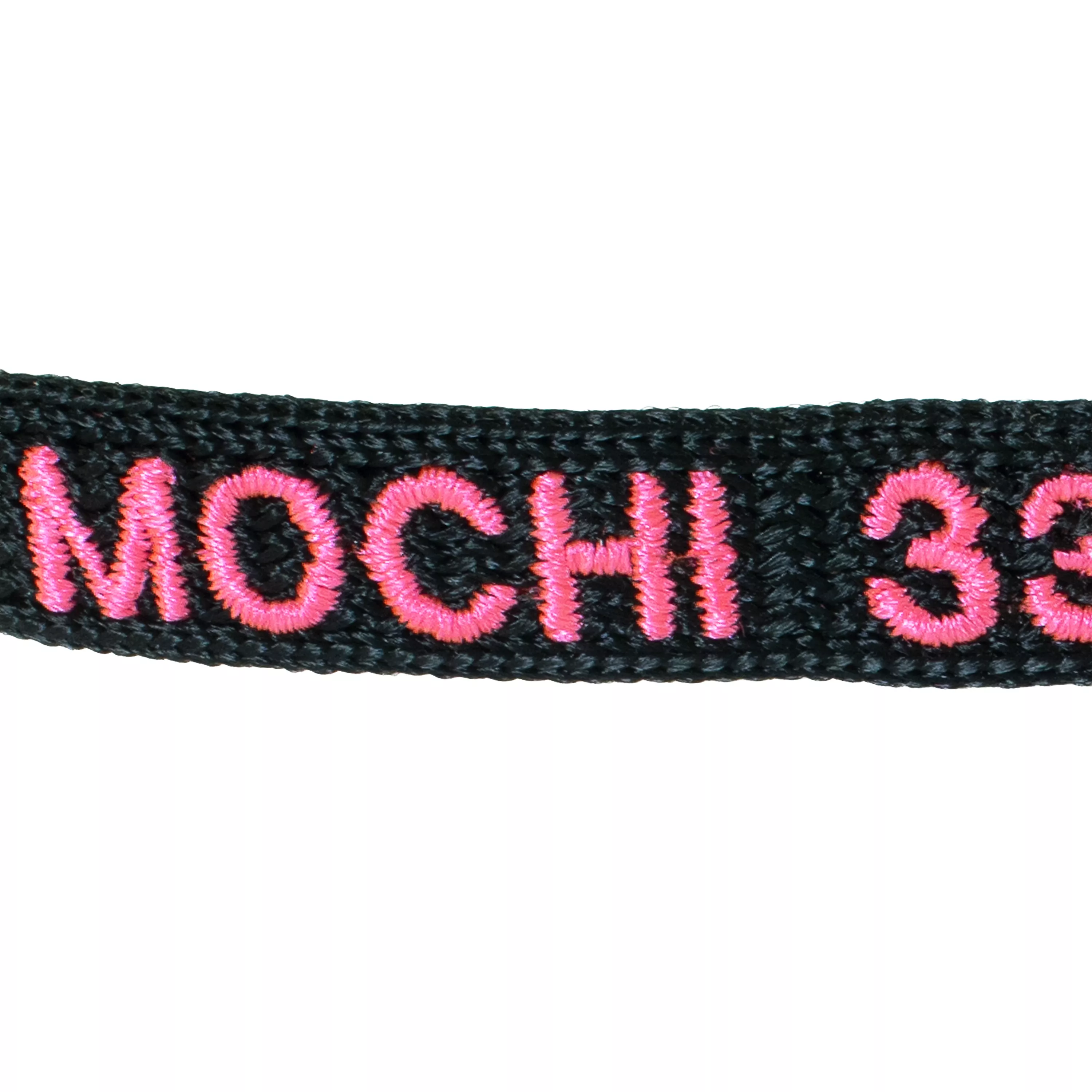 Close-up of black pet collar with embroidered personalized name and phone number.